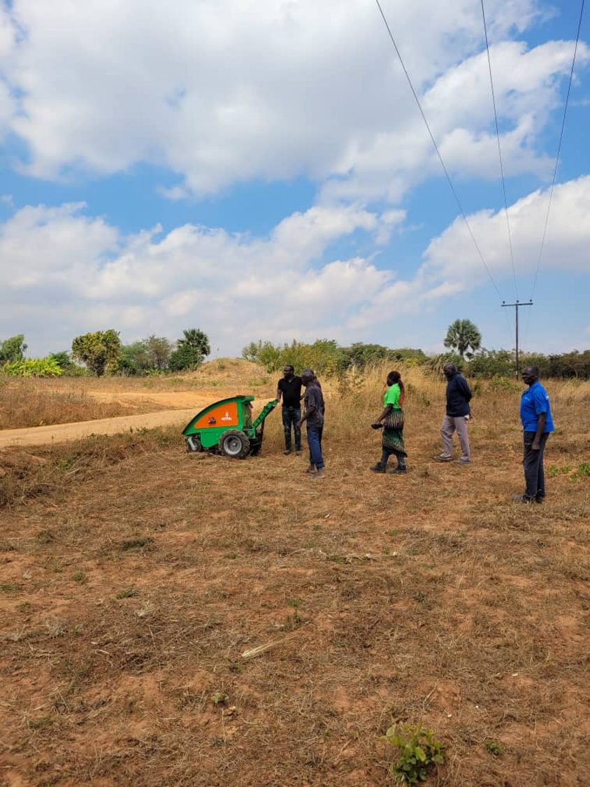 The Aftrak tractor standing on dry ground at Emisizini with a group walking across to it