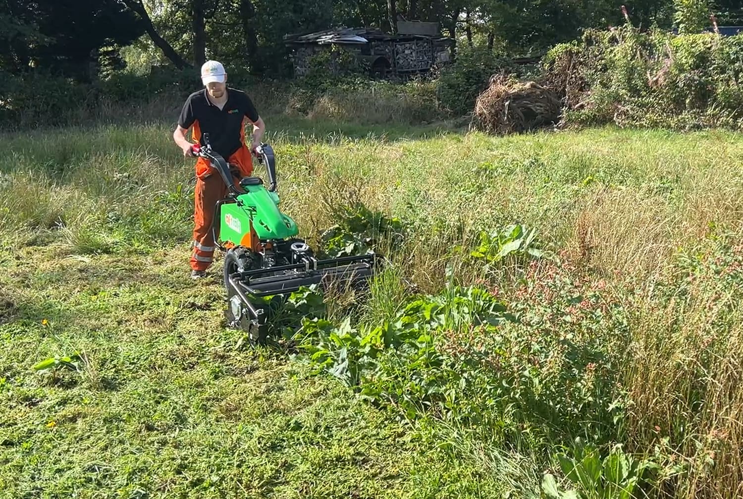 An operator taking the flail mower through thick weeds and rough grass