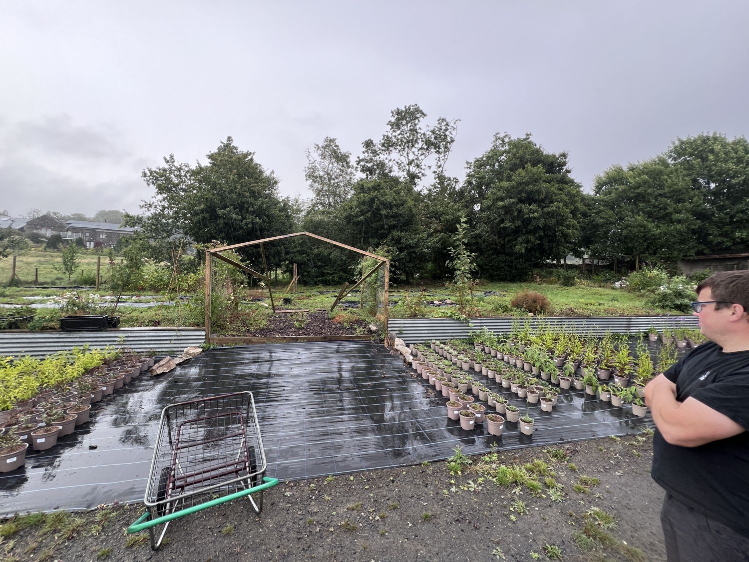 Bare weed-membrane ground with a timber frame and open Dales landscape beyond