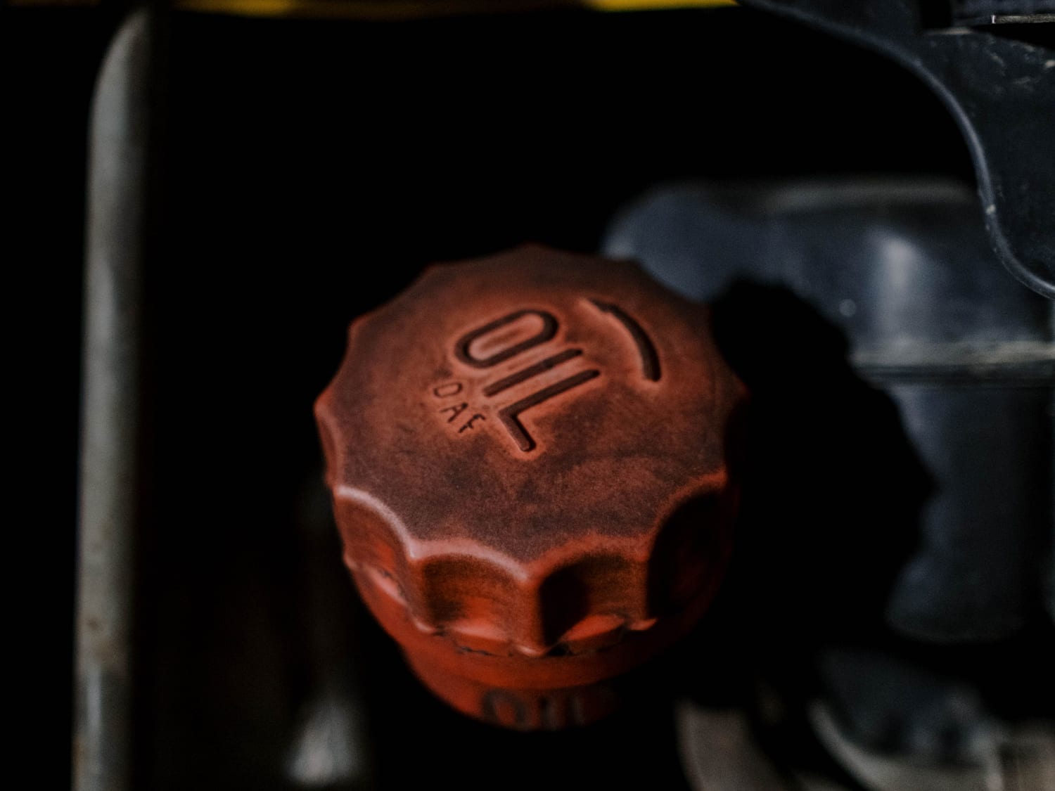 A red oil filler cap on a small petrol engine
